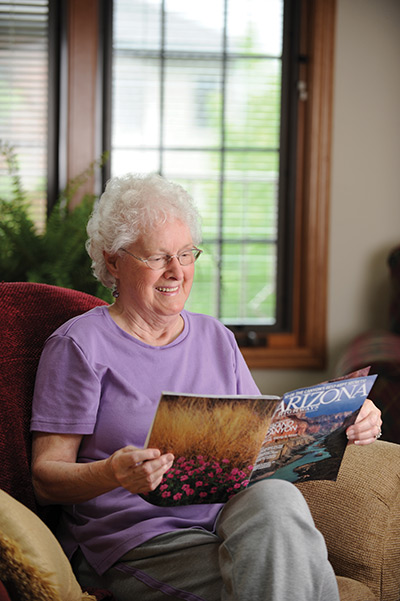 Tenant reading in community living room at Ellen Kennedy Living Center Tenant reading in community living room at Ellen Kennedy Living Center