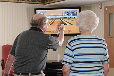 Tenant reading in community living room at Ellen Kennedy Living Center Ellen Kennedy Living Center tenants enjoy activities program.